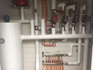 Radiant heating manifold with copper tubing, zone valves, and mixing valve installation